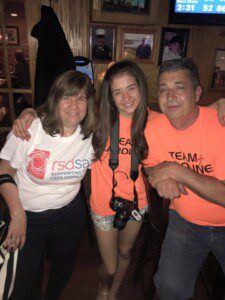 Caroline sits with some of her supporters at a fundraiser for Team Caroline and RSDSA (CRPS RSD)