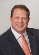 Man in a headshot with an orange tie