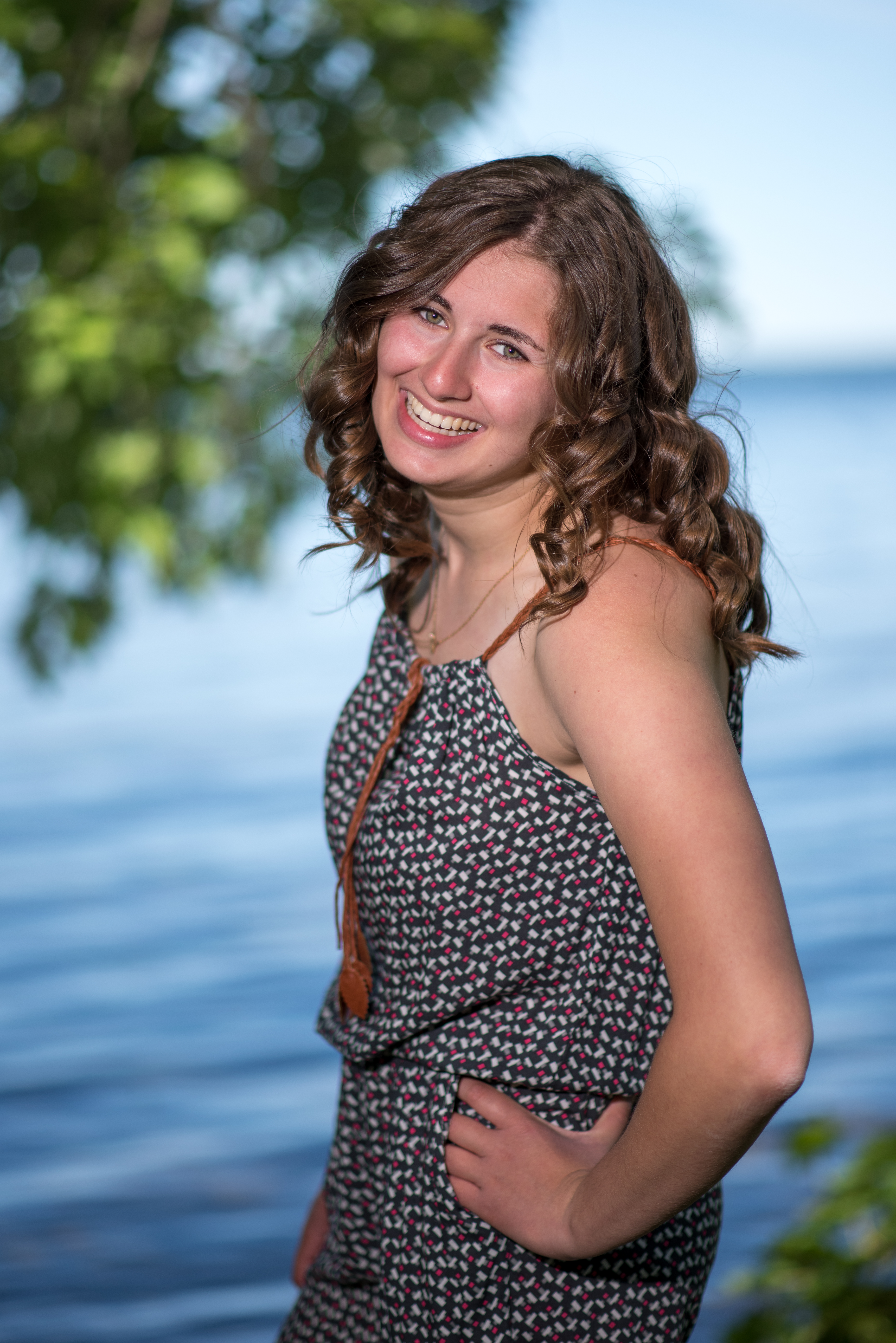Woman with curly hair posing in front of water